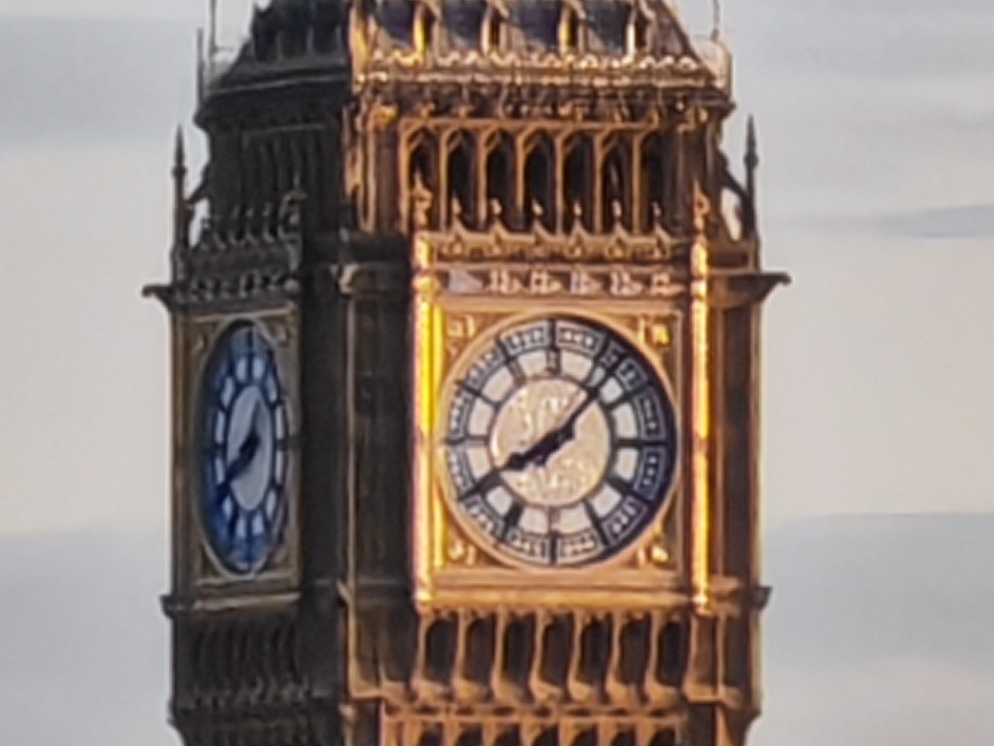 A clock tower with a large clock on it with Big Ben in the background

Description automatically generated